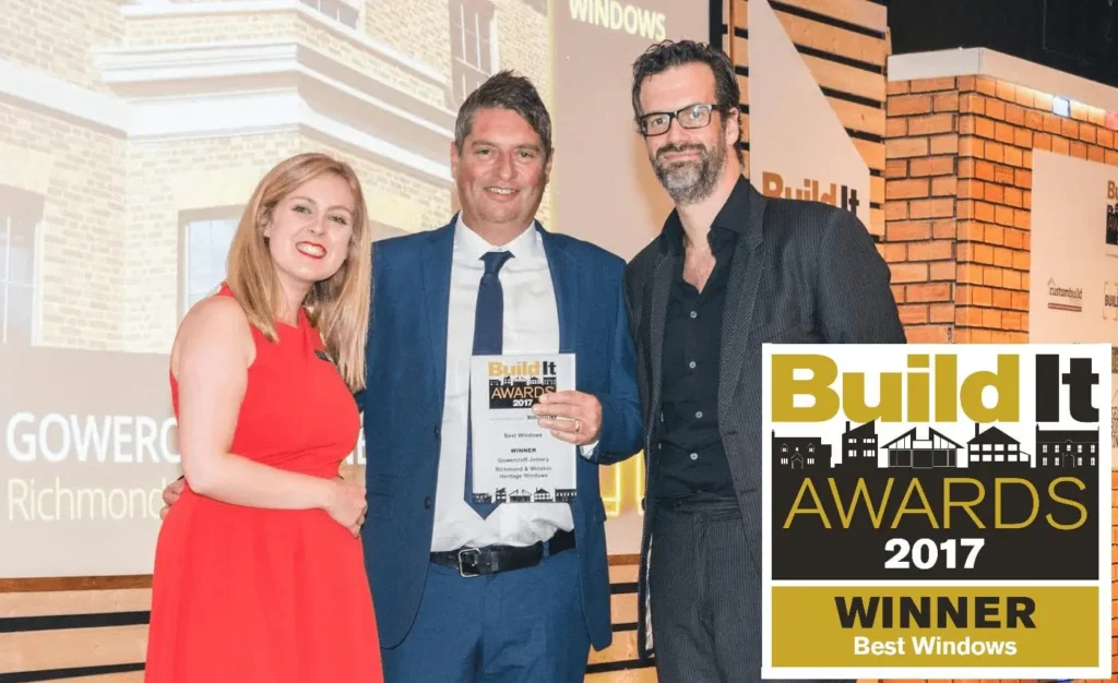 Gowercroft Joinery receiving the Best Windows award at the 2017 Build It Awards for their Richmond and Winston heritage windows, presented on stage with the official trophy.