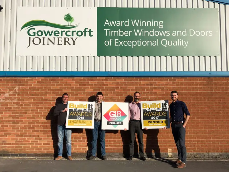 The Gowercroft Joinery team standing outside their Derbyshire workshop, proudly holding signage for multiple award recognitions including the Build It Awards 2017 Winner, Build It Awards 2018 Shortlisted, and G18 Awards Finalist.