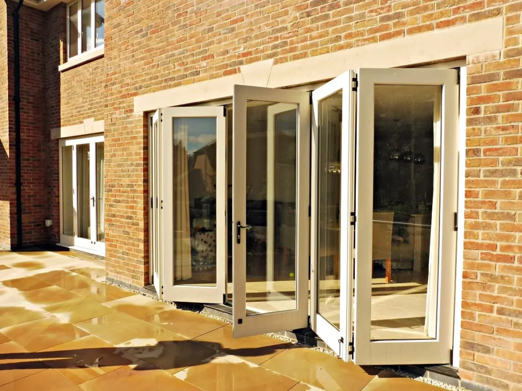 Tutbury bifold door 5 five panel painted strutt yellow clear glass partially open brick building stone lintel external view