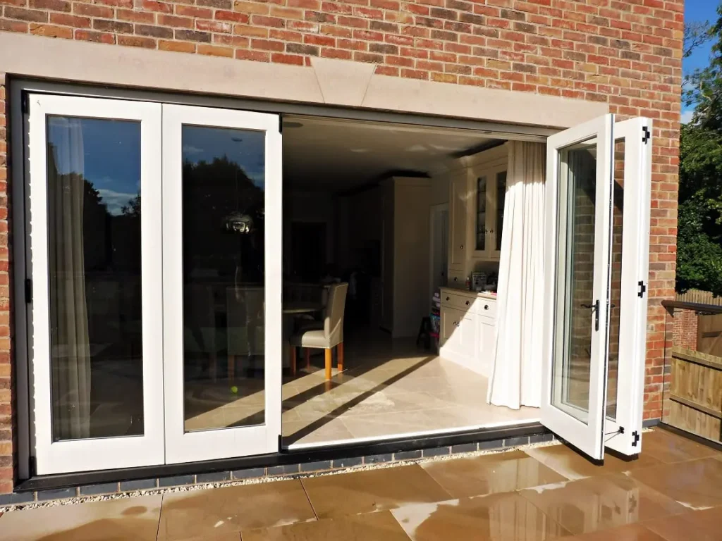 Tutbury bifold door 5 five panel painted strutt yellow clear glass partially open brick building stone lintel external view