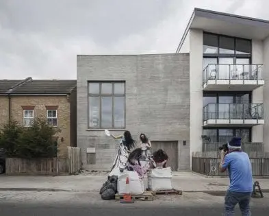 Juergen Teller’s concrete photographic studio in London featuring minimalist timber-framed windows designed by Gowercroft, with a photoshoot taking place in front of the building.