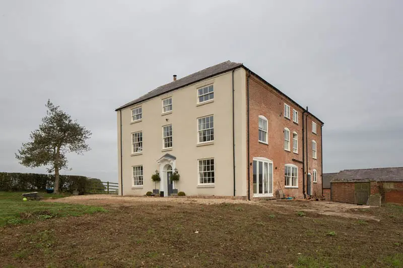 Large Georgian-style country house in Leicester featuring timber sliding sash windows with traditional astragal bars, supplied and fitted by Gowercroft Joinery.