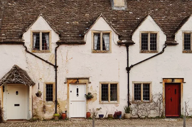 Traditional stone-fronted listed cottages with leaded glass windows and timber doors, illustrating heritage architecture and window styles suitable for listed buildings.