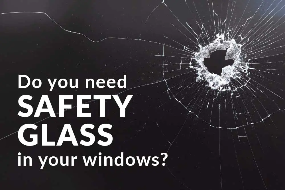 Close-up of shattered safety glass with a hole in the centre, illustrating the importance of using safety glass in windows to prevent injury. Text overlay reads, "Do you need safety glass in your windows?"