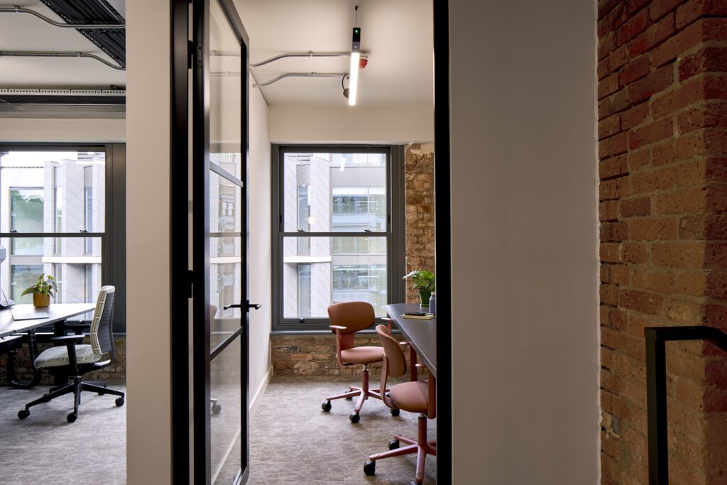 Stylish private office with sash windows – The Waterman Building, Farringdon, London
A modern workspace with a glass-partitioned private office, featuring restored Chatsworth sliding sash windows set within exposed brick walls. The warm natural light and a mix of industrial and heritage design elements create a characterful yet functional office environment.