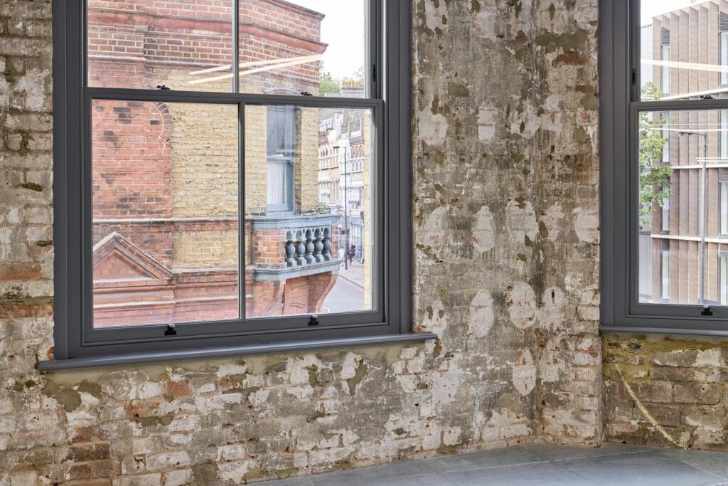 Close-up of a Chatsworth sash window with exposed brick – The Waterman Building, Farringdon, London
A detailed shot of a heritage-style sliding sash window set against exposed brick walls. The deep grey timber frame contrasts with the warm brick tones, showcasing the seamless blend of old and new in this conservation project.