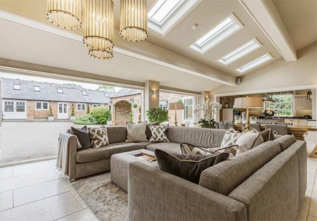 A Halifax Heritage Bifolding Door seamlessly opens up this elegant living space, blurring the line between indoors and out. The expansive timber-framed panels fold away effortlessly, creating a fully open façade that invites in natural light and fresh air. Perfect for grand country homes and heritage properties, this design offers the charm of traditional craftsmanship with the flexibility of modern bifolds—delivering timeless style with contemporary performance.