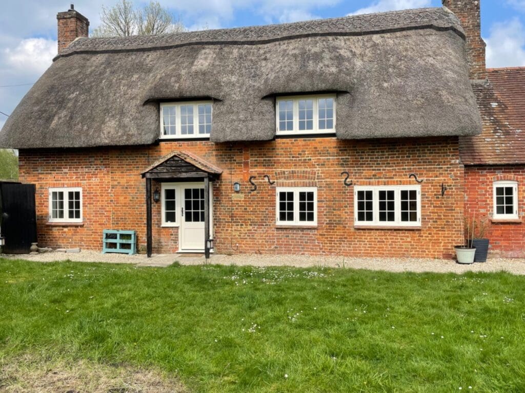 Elevation Richmond Churchill thatch brick white painted cottage