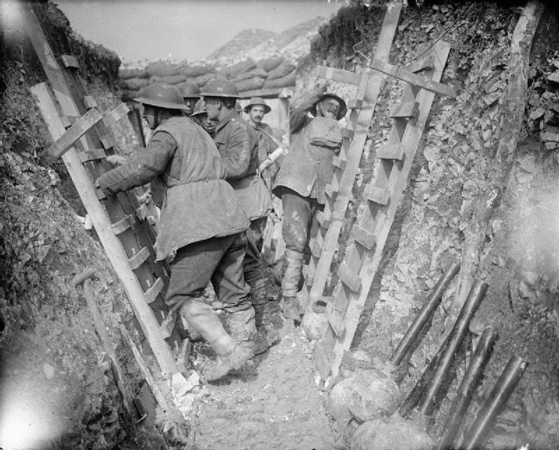 Black-and-white historical photograph showing Royal Engineers of the British Army repairing or constructing scaling ladders near Arras, France, on 8 April 1917. Several soldiers in uniform are working with timber beams and tools in a trench or dugout area, surrounded by debris and construction materials. This is a wartime scene captured during World War I, used here for illustrative purposes.
